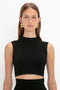 A person with long hair wearing a versatile, sleeveless black Victoria Beckham VB Body Scallop Trim Tank Top In Black and geometric earrings stands against a plain white background, looking directly at the camera.