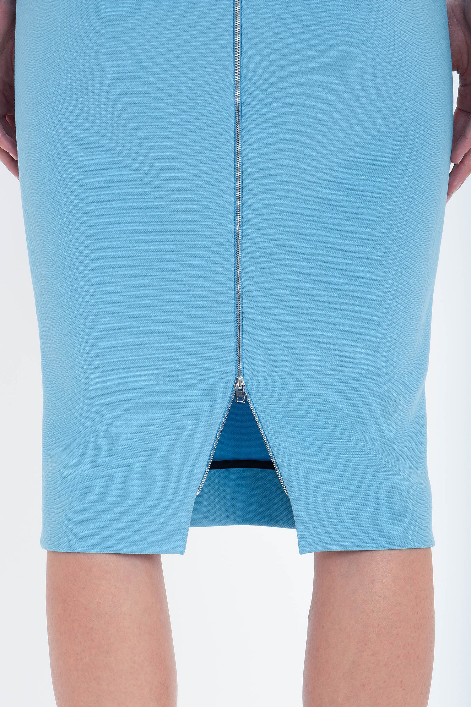 Close-up view of the back of the Exclusive Fitted T-Shirt Dress In Periwinkle Blue by Victoria Beckham with a central zipper slightly open from the bottom, revealing a small slit.