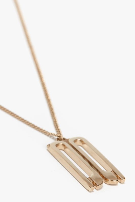An Exclusive Frame Necklace In Gold by Victoria Beckham featuring a slim, rectangular design with two cutout vertical lines, reminiscent of the chic style found in Victoria Beckham accessories.