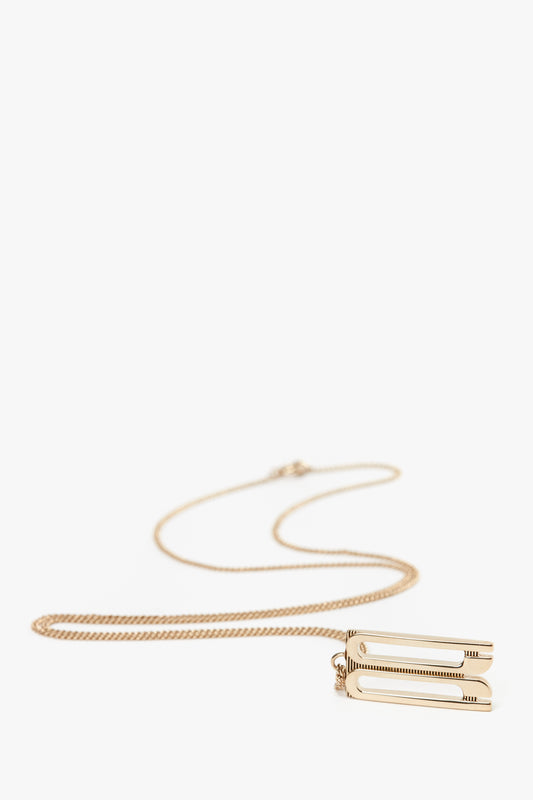 An Exclusive Frame Necklace In Gold with a thin chain and a rectangular frame charm pendant featuring a minimalist design, inspired by Victoria Beckham accessories. Crafted from gold-plated brass, it's the perfect blend of elegance and modern style by Victoria Beckham.