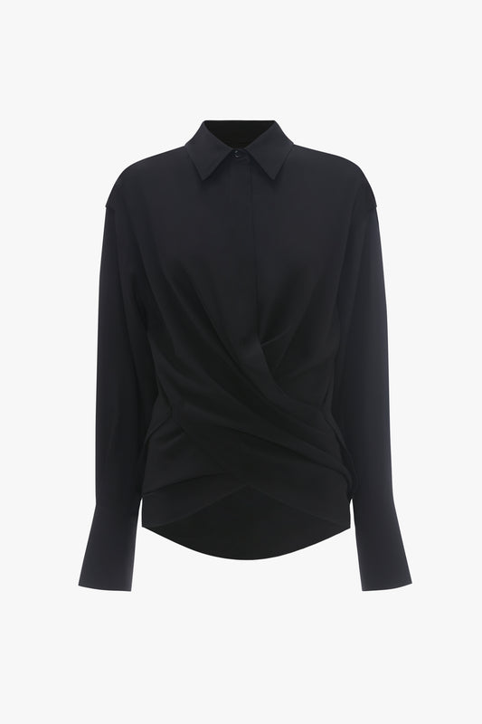 A black long-sleeve silk Wrap Front Blouse In Black with a unique twisted front design and a classic collar, displayed against a white background by Victoria Beckham.