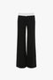 A pair of Victoria Beckham Side Panel Trouser In Black with a chic white waistband, viewed from the back.