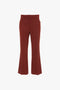 A pair of Victoria Beckham Wide Cropped Flare Trousers In Russet viewed from the front.