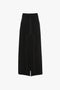 A Deconstructed Floor-Length Skirt In Black by Victoria Beckham with visible stitch detailing, a front slit, and a subtle box pleat detail.