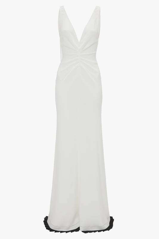 A Victoria Beckham Exclusive V-Neck Gathered Waist Floor-Length Gown In Ivory with an hourglass silhouette and a deep V-neck, featuring a long, flowing skirt.