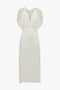 An Exclusive V-Neck Ruffle Midi Dress In Ivory with short, frilled sleeves and a V-neckline, reminiscent of Victoria Beckham's elegant designs, displayed on a white background.