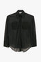 A black, long-sleeved, sheer button-up Pocket Detail Shirt In Black by Victoria Beckham with two chest pockets and a collared neckline.