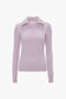 Lilac long-sleeve ribbed sweater with a collar and V-neckline, reminiscent of a textured knit, displayed on a white background. It's the Double Collared Jumper In Petunia by Victoria Beckham.