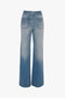 A pair of Victoria Beckham Alina High Waisted Jean In Light Summer Wash, exuding vintage denim charm, displayed on a white background.