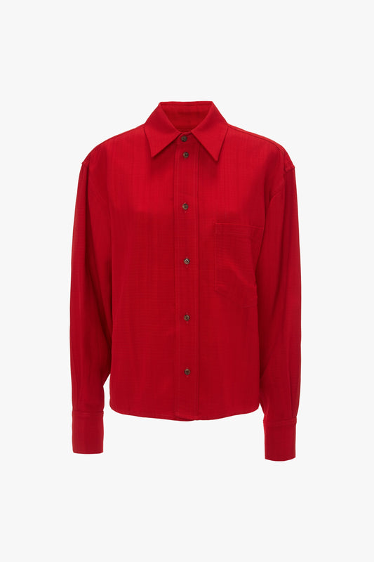 A red **Cropped Long Sleeve Shirt In Carmine** with a pocket on the left chest, reminiscent of a sophisticated **Victoria Beckham** monogram style.