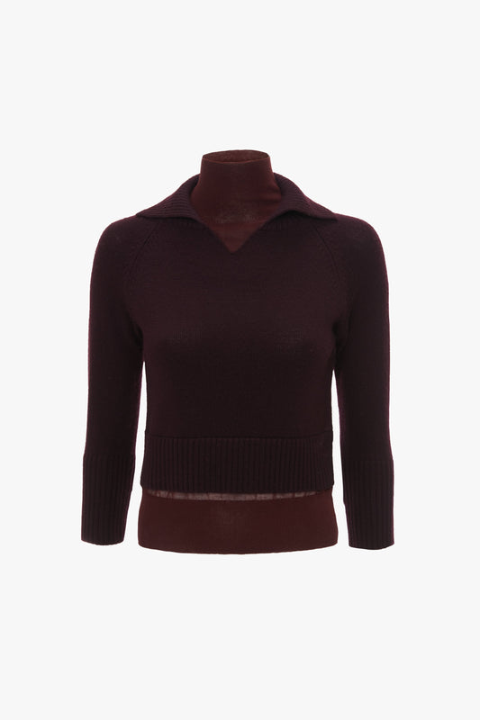 A dark burgundy, long-sleeve, V-neck sweater made of merino wool knit is displayed on a mannequin with a plain white background. The fitted silhouette features ribbed cuffs and hem, exemplifying timeless elegance. This is the Double Layer Top in Deep Mahogany by Victoria Beckham.