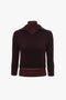 A dark burgundy, long-sleeve, V-neck sweater made of merino wool knit is displayed on a mannequin with a plain white background. The fitted silhouette features ribbed cuffs and hem, exemplifying timeless elegance. This is the Double Layer Top in Deep Mahogany by Victoria Beckham.