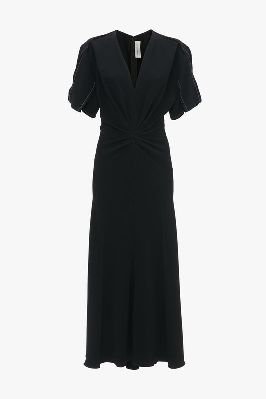 A black Gathered V-Neck Midi Dress in Black with short, puffy sleeves, a figure-flattering stretch fabric, a deep V neckline, and a front knot detail from Victoria Beckham.