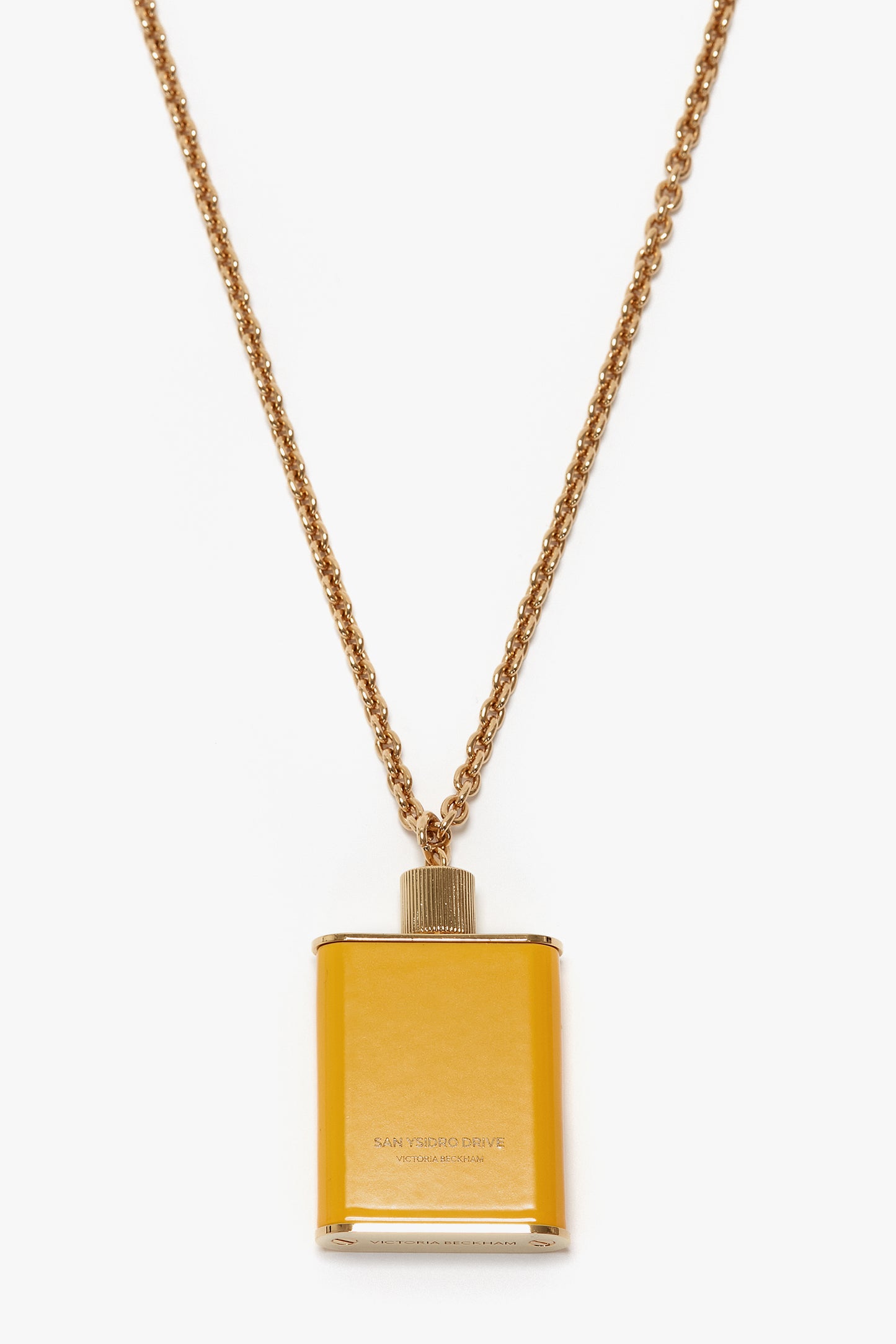 Perfume Bottle Necklace In San Ysidro Drive with a rectangular pendant designed to resemble a flask, featuring gold brushed brass finish and subtle Victoria Beckham branding.