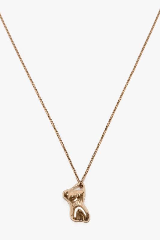 A light gold chain necklace with a small, bear-shaped pendant made from 100% brass is the Exclusive Body Charm Necklace In Light Gold by Victoria Beckham.