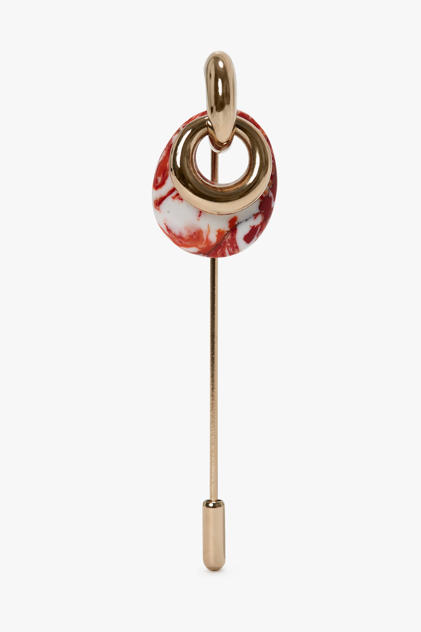 A decorative pin featuring a Light Gold/Orange metal design with a red and white marbled circular element near the top, made in Italy, is the Exclusive Resin Charm Brooch In Light Gold-Orange by Victoria Beckham.