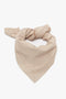 A versatile Leather Scarf In Taupe by Victoria Beckham folded into a triangular shape with a knot at the top, this piece is an elevated essential.