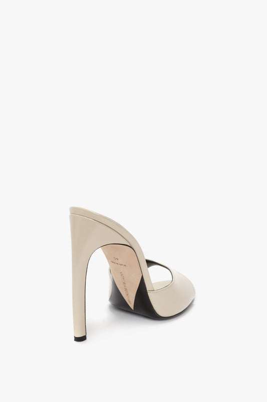 A single beige Classic Mule In Macadamia calf Leather with a glossy finish, crafted from calf leather by Victoria Beckham, features an open back and a pointed toe, showcased on a white background.