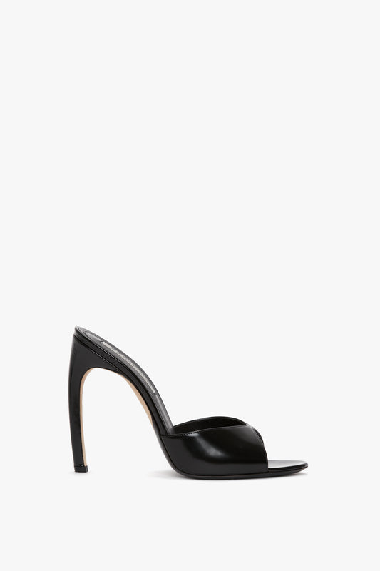 The Classic Mule In Black Calf Leather by Victoria Beckham, crafted from luxury calf leather with a seductive curved heel, is displayed against a plain white background.