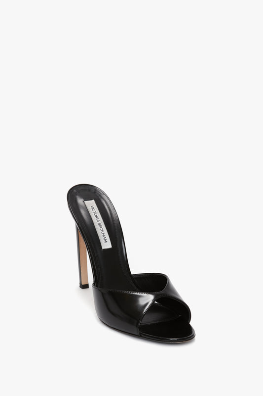 A single Classic Mule In Black Calf Leather by Victoria Beckham with an open-toe design and a seductive curved heel, crafted from luxury calf leather, displayed on a white background.