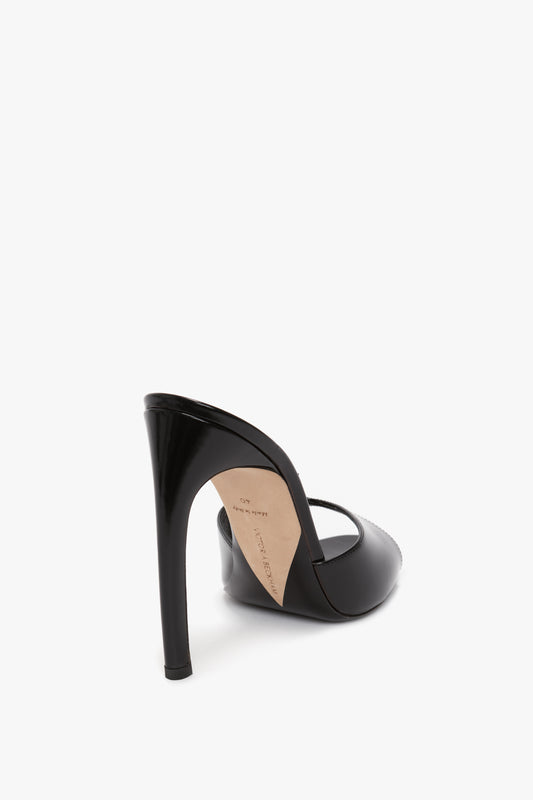 A classic mule made from luxury calf leather, the Victoria Beckham Classic Mule In Black Calf Leather features a seductive curved heel, closed pointed toe, and an open back, all viewed from a rear angle against a white background.
