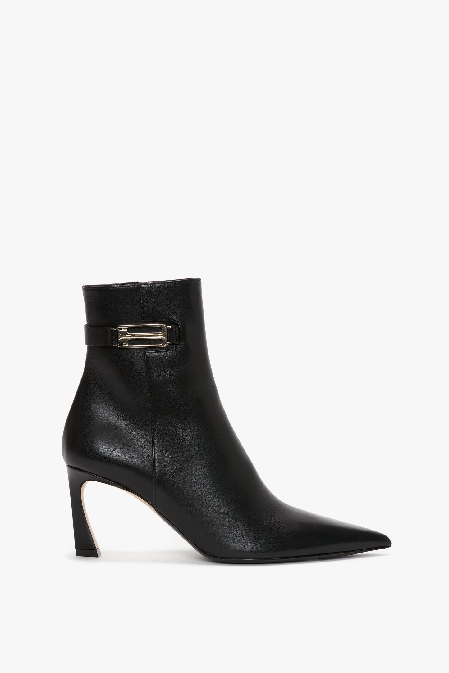 A black leather ankle boot with a pointed toe, a mid-height heel, and a buckle strap detail near the top offers a refined silhouette, making the Pointed Toe Half Boot In Black Soft Calf Leather by Victoria Beckham an ideal wear-anywhere ankle boot.