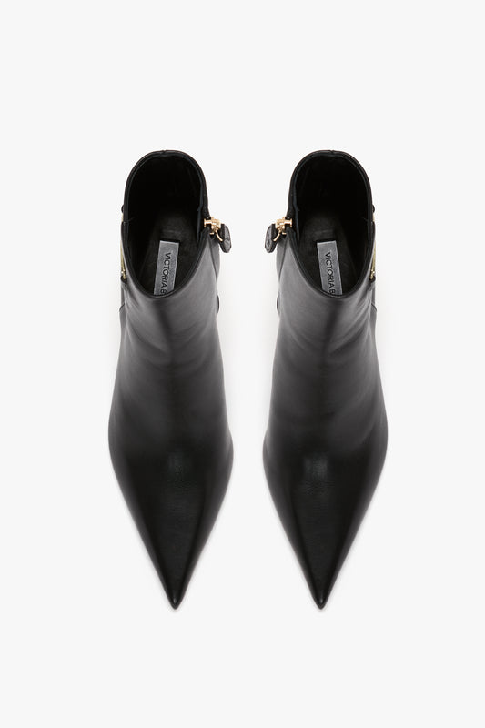Top-down view of a pair of Victoria Beckham Pointed Toe Half Boot In Black Soft Calf Leather with side zippers on a white background, showcasing their wear-anywhere refined silhouette.