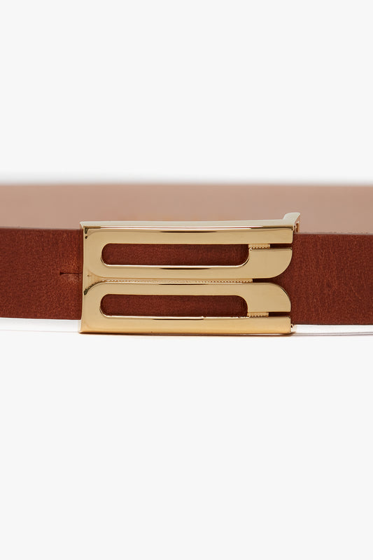 Close-up of a Victoria Beckham Exclusive Micro Frame Belt In Tan Leather, showcasing a gold rectangular buckle with two parallel cutout slots.