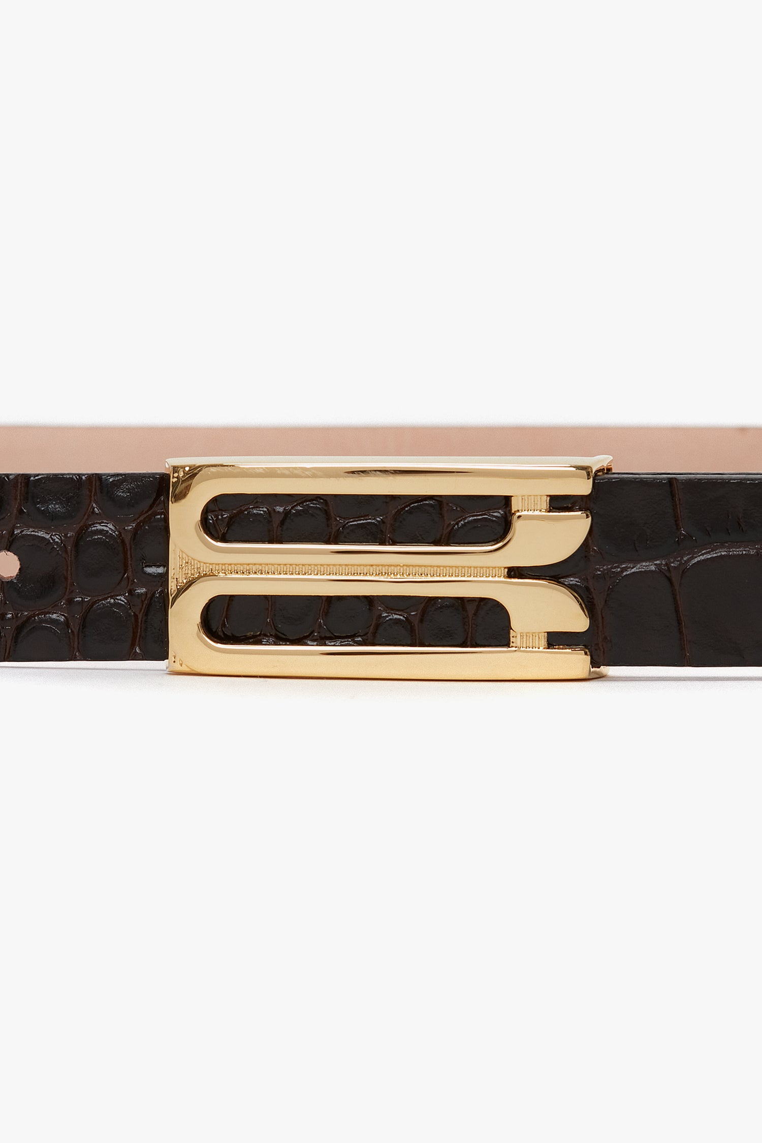 A close-up of a Victoria Beckham Frame Belt In Espresso Croc Embossed Calf Leather with gold hardware detailing the buckle.