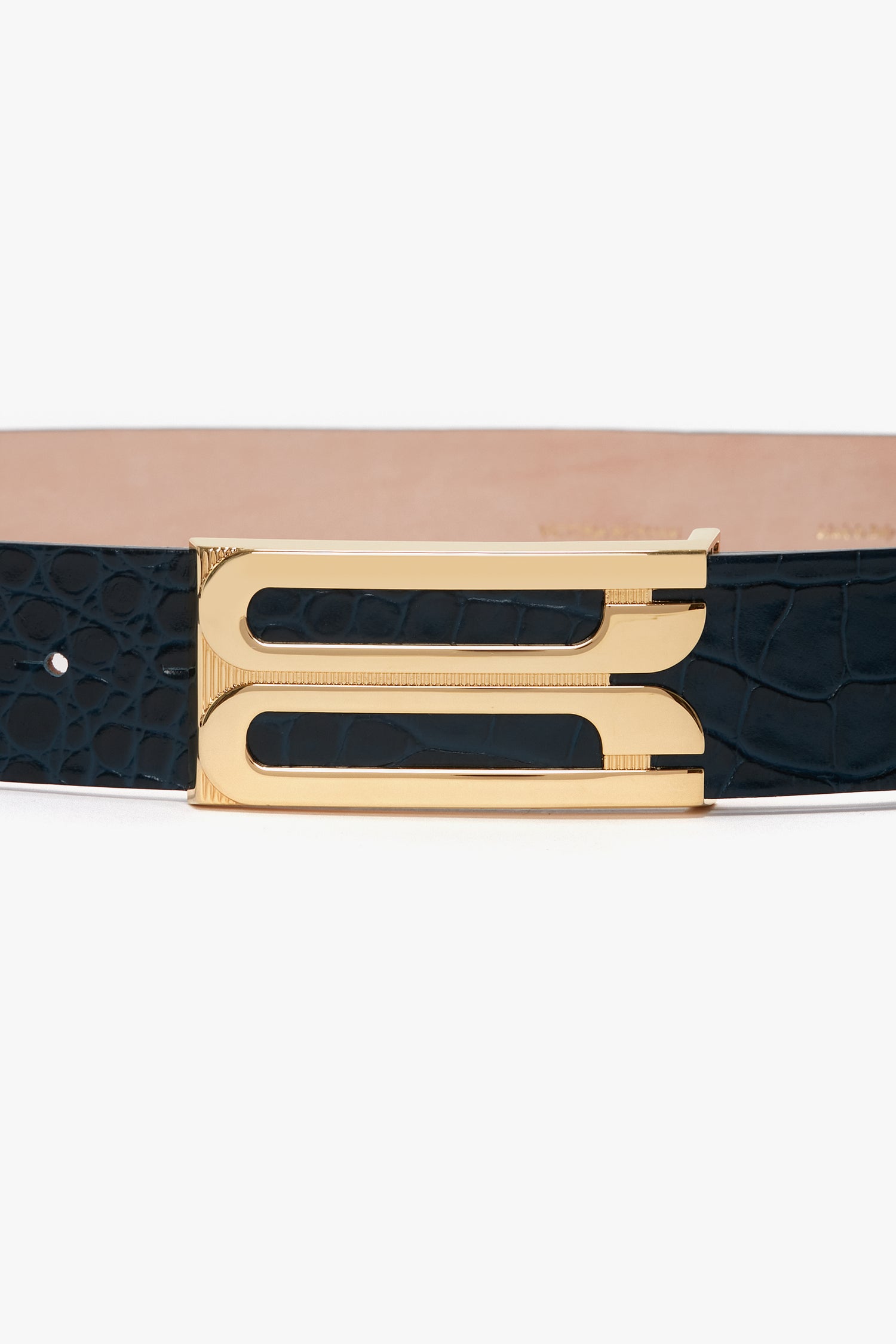 A black croc-embossed calf leather belt with luxury gold hardware, featuring a rectangular buckle and a double loop design is replaced by the Jumbo Frame Belt In Midnight Blue Croc Embossed Calf Leather from Victoria Beckham.