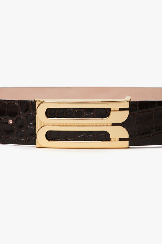 A close-up of the Jumbo Frame Belt In Espresso Croc Embossed Calf Leather by Victoria Beckham, with luxury gold hardware featuring a modern design.