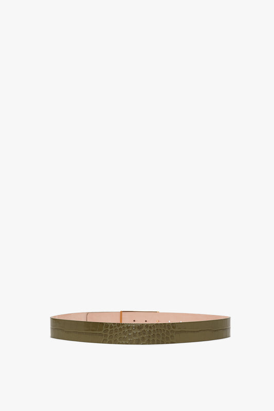 Image of a green leather Exclusive Jumbo Frame Belt In Khaki Croc Embossed Calf Leather by Victoria Beckham with a textured croc-embossed calf leather design and luxury gold hardware, paired with an internal beige lining, shown in a flat, circular arrangement.