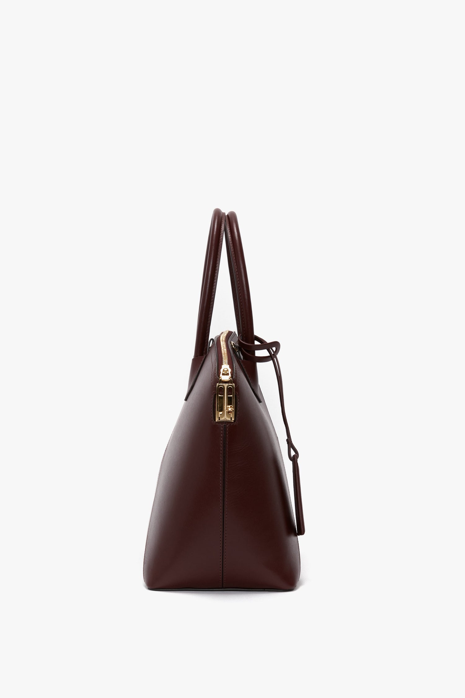 Side view of a Victoria Beckham Victoria Bag In Burgundy Leather with gold hardware and a chic padlock closure.