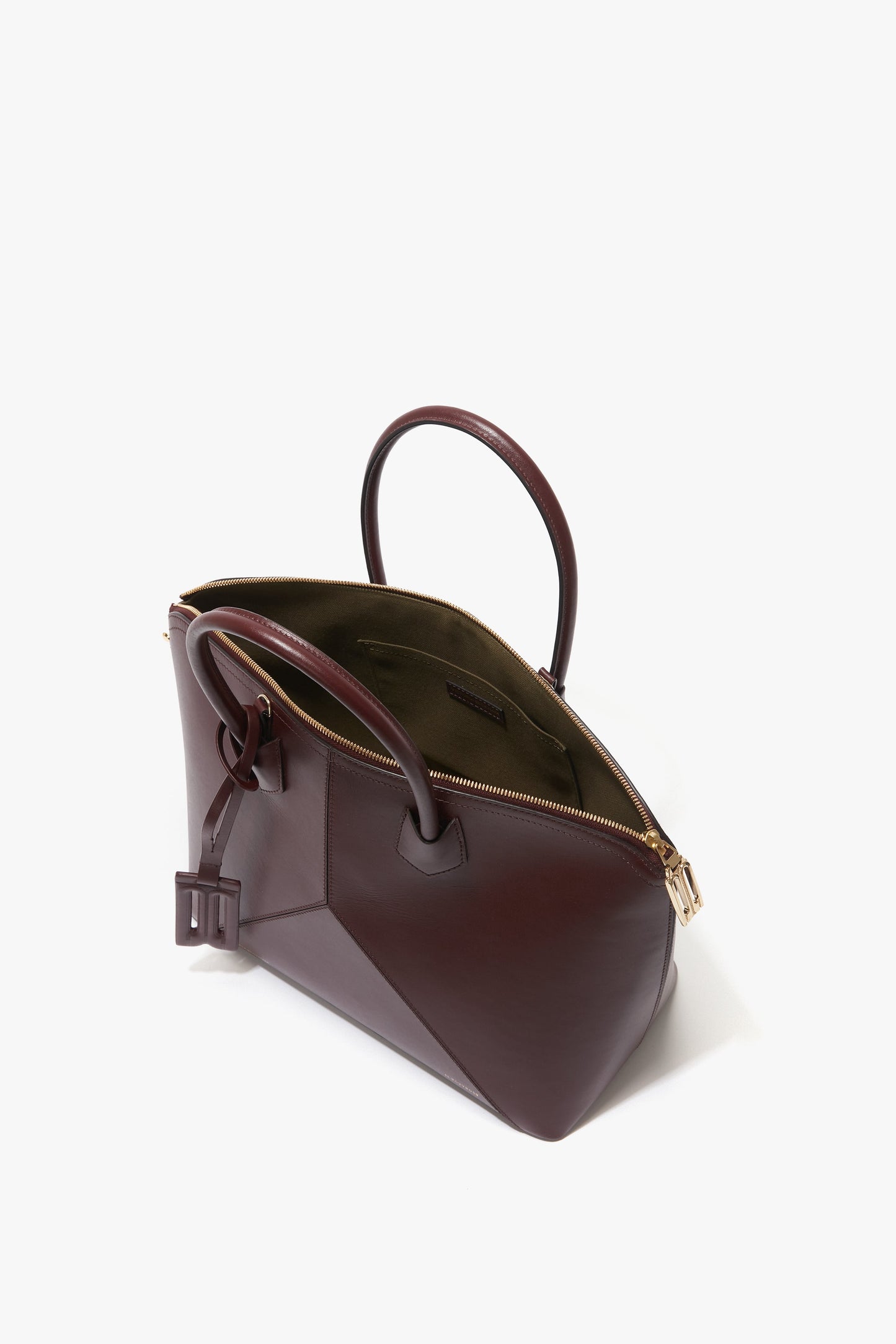 Open Victoria Beckham Victoria Bag In Burgundy Leather with a rectangular shape, featuring gold-tone zippers, dual handles, and a small external pocket with a buckle detail and padlock closure.