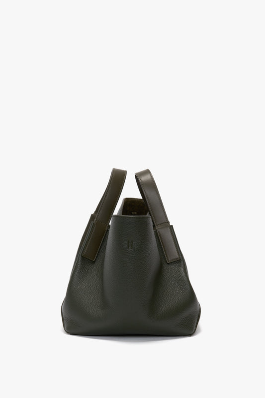 A dark green calf leather W11 Mini Tote Bag In Loden Leather by Victoria Beckham with short handles, displayed against a white background.