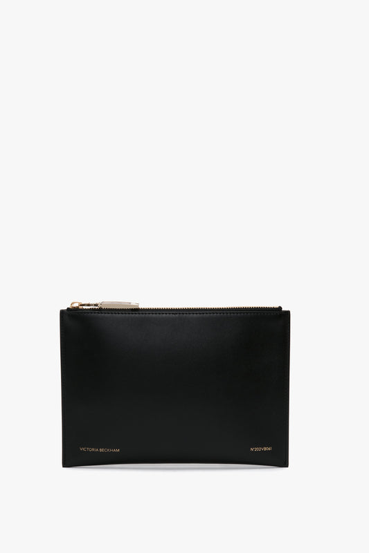A B Frame Pochette In Black Leather, featuring a zipper top, gold hardware, and the brand name "Victoria Beckham" in small letters at the bottom. Perfect for the AW24 season.