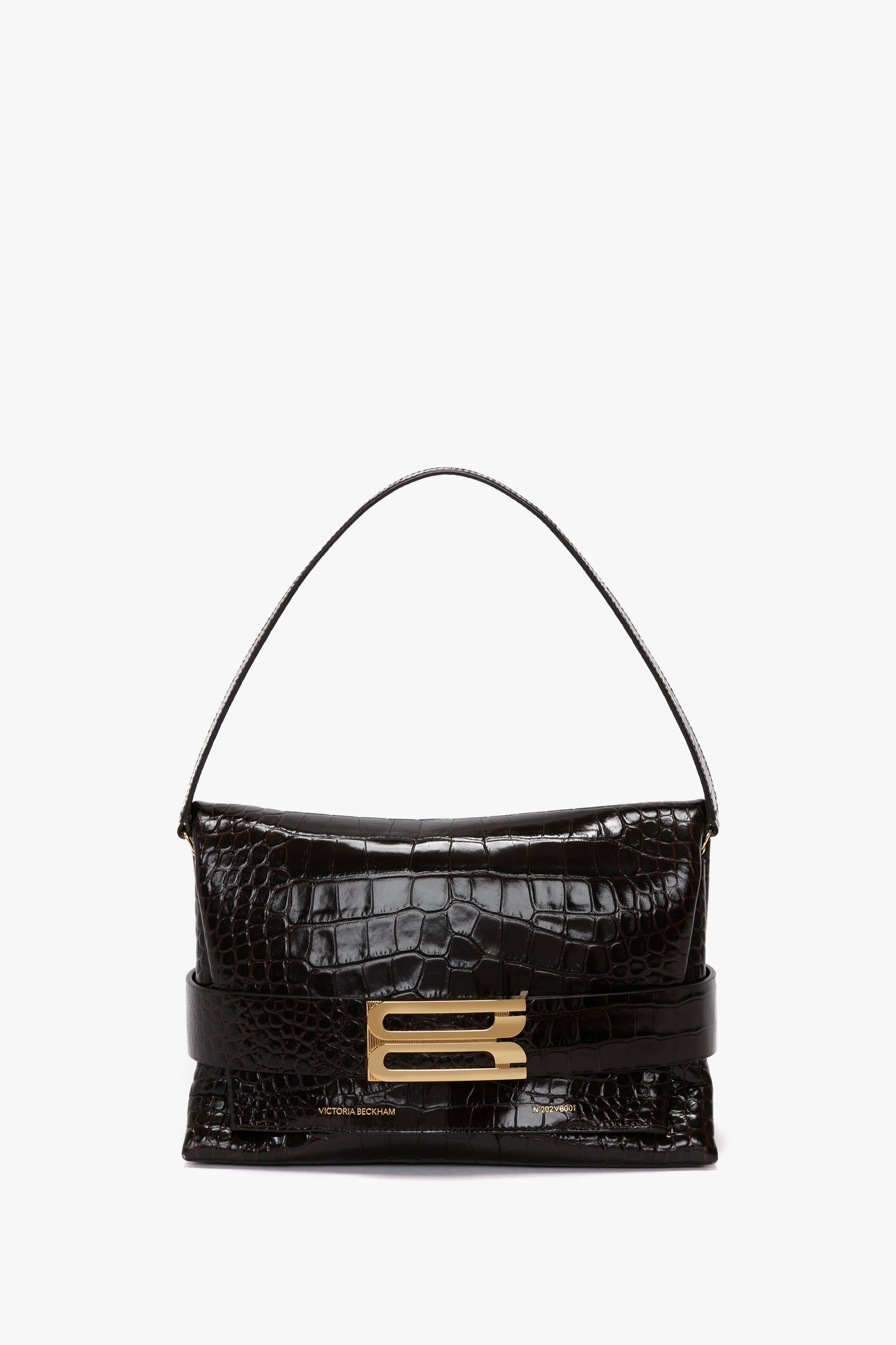 The B Pouch Bag In Croc Effect Espresso Leather from Victoria Beckham features an embossed crocodile print, a detachable shoulder strap, and a gold-tone rectangular buckle detail on the front.