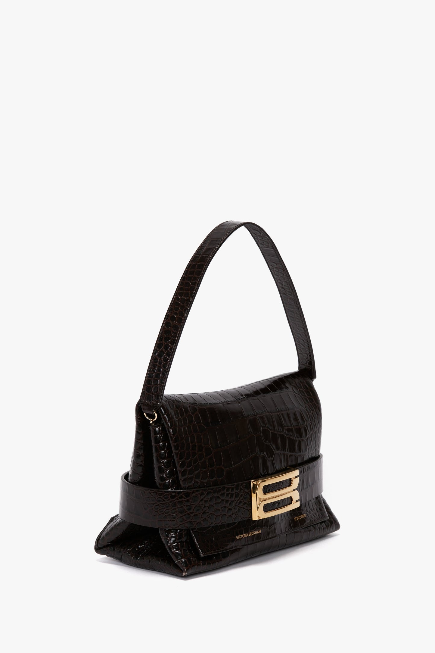 A small, black handbag crafted from calf leather with an embossed crocodile print, featuring a short strap and a gold buckle closure is the **B Pouch Bag In Croc Effect Espresso Leather by Victoria Beckham**.