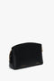 A black, zippered Victoria Crossbody Bag In Black Leather from Victoria Beckham made from textured calf leather with gold-tone hardware, subtle branding at the front, and an adjustable strap for versatile wear.