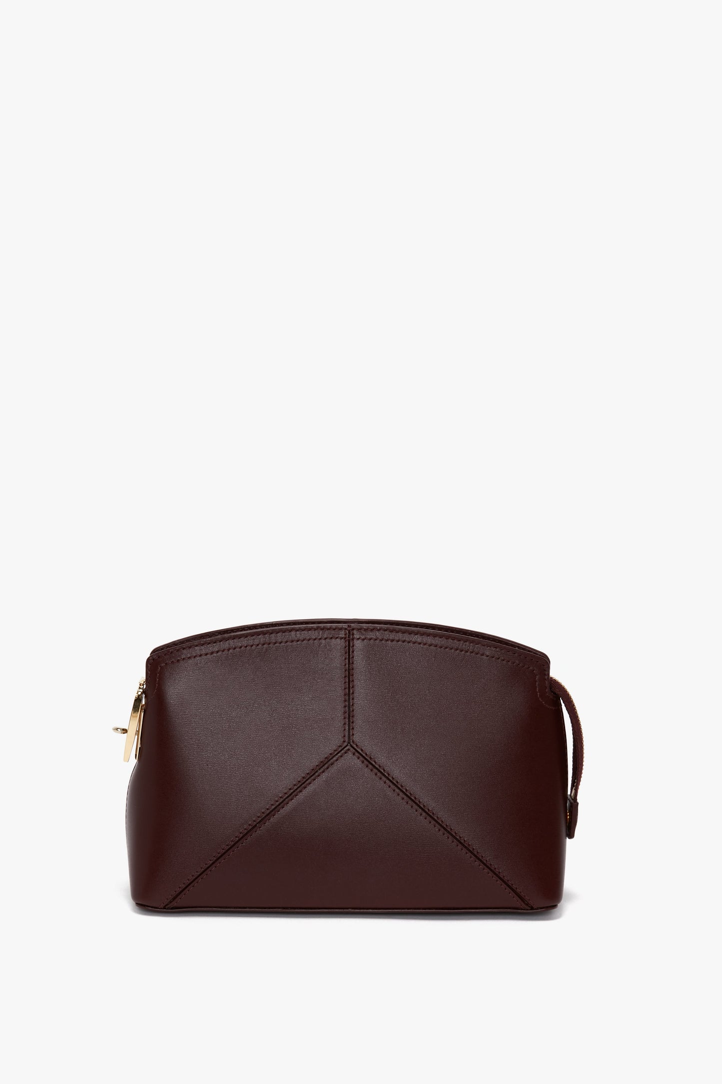A dark brown leather clutch bag with a geometric design and a gold zipper closure against a white background, made from luxurious burgundy calf leather, has been replaced in the sentence with the Victoria Crossbody Bag In Burgundy Leather by Victoria Beckham.