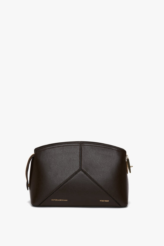 Front view of the Exclusive Victoria Crossbody Bag In Brown Leather by Victoria Beckham with a structured design and gold-tone zipper. Made from calf leather, it features an adjustable strap and subtle branding text at the bottom.