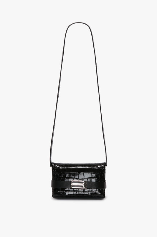 A Mini B Pouch Bag In Croc Effect Black Leather from Victoria Beckham, featuring a decorative silver buckle and a convenient crossbody strap for easy wear.