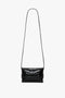 A small black shoulder bag featuring a textured crocodile pattern, crafted from calf leather. The Mini B Pouch Bag In Croc Effect Black Leather by Victoria Beckham boasts a long crossbody strap for convenience.