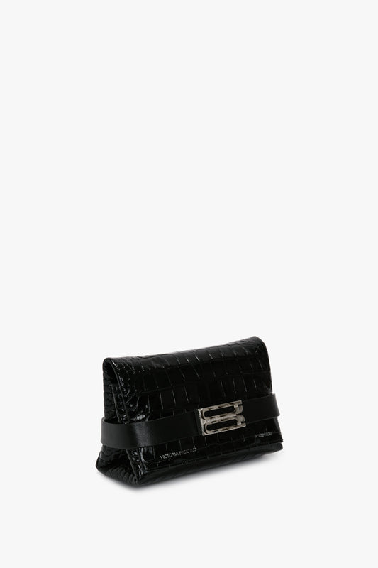 A small black calf leather clutch bag with a crocodile texture, featuring a silver rectangular clasp, a Mini B Pouch Bag In Croc Effect Black Leather by Victoria Beckham, and a horizontal black strap detail.