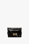 Black, crocodile-textured calf leather clutch bag with gold accents and a rectangular clasp. This Mini B Pouch Bag In Croc Effect Espresso Leather features "Victoria Beckham" embossed in gold on the lower left corner and comes with a detachable crossbody strap for versatile styling.