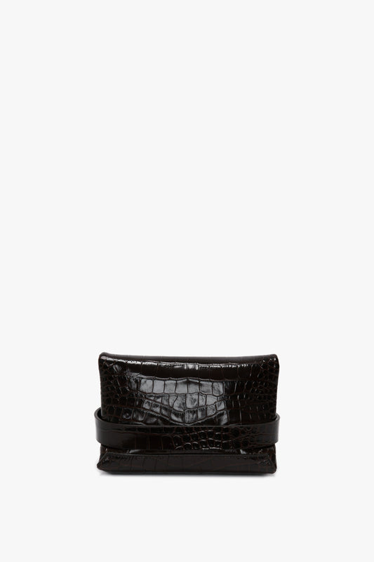 A **Mini B Pouch Bag In Croc Effect Espresso Leather** from **Victoria Beckham**, featuring a folded top design and crafted from calf leather, paired with a detachable crossbody strap. Isolated against a white background.