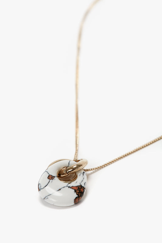 A Victoria Beckham Exclusive Resin Pendant Necklace In Light Gold-White, featuring white marble and brown veins, made from 100% brass.