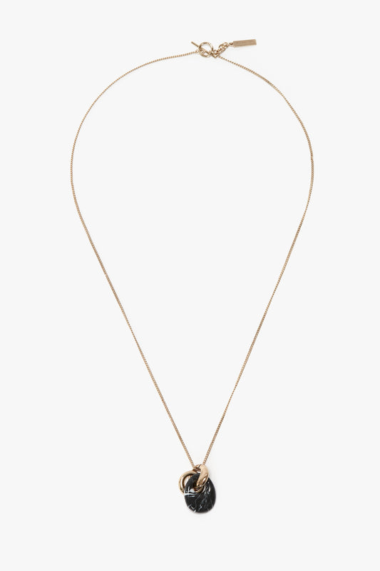 An elegant Light Gold/Black chain necklace with a black resin pendant and metallic ring detail, expertly crafted in Italy, the Exclusive Resin Pendant Necklace In Light Gold-Black by Victoria Beckham.