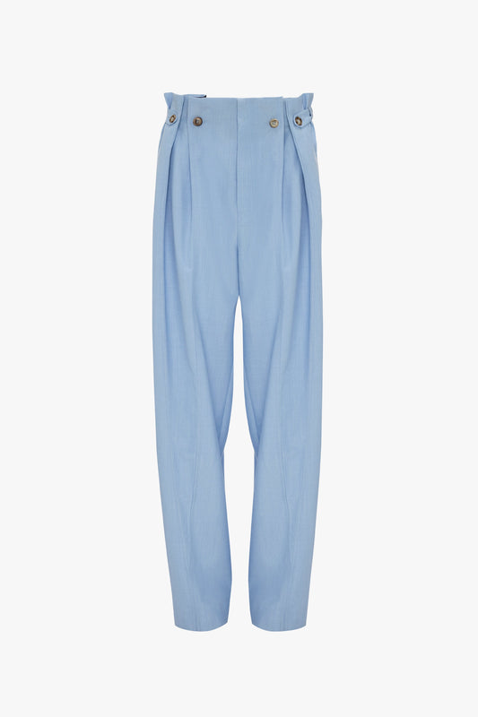 Light blue, high-waisted Victoria Beckham Gathered Waist Utility Trouser In Oxford Blue with pleats and button details at the waistband, displayed against a white background.