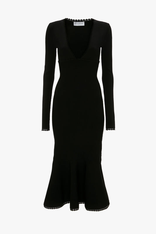 A black, long-sleeve, knee-length VB Body Long Sleeve V Neck Dress In Black by Victoria Beckham with a deep V-neckline and scalloped edges along the neckline, sleeve cuffs, and hem.